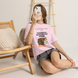 Woman sitting with phone wearing A Woman Who Reads Is Powerful Dangerous and Free feminist T-shirt