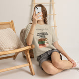 Woman sitting with phone wearing A Woman Who Reads Is Powerful Dangerous and Free feminist T-shirt